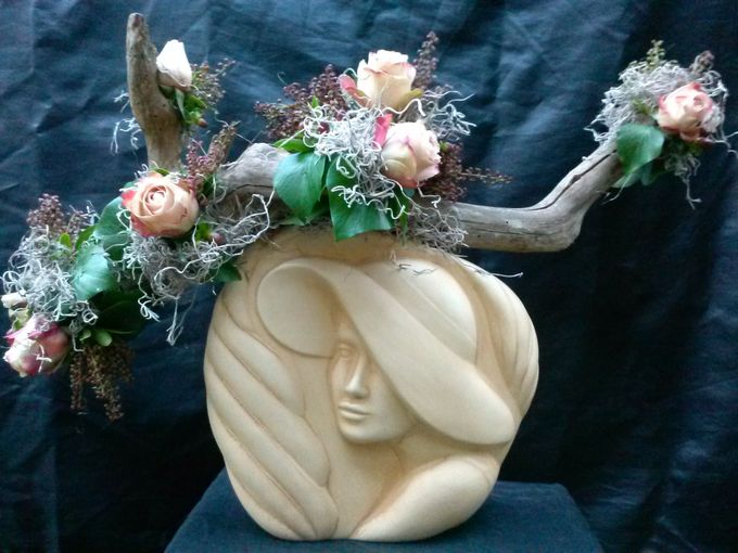 Kerstdecoratie met Rozen,Hederablad,Photinia,Tilantia op een houtstronk samen op een prachtige vaas!