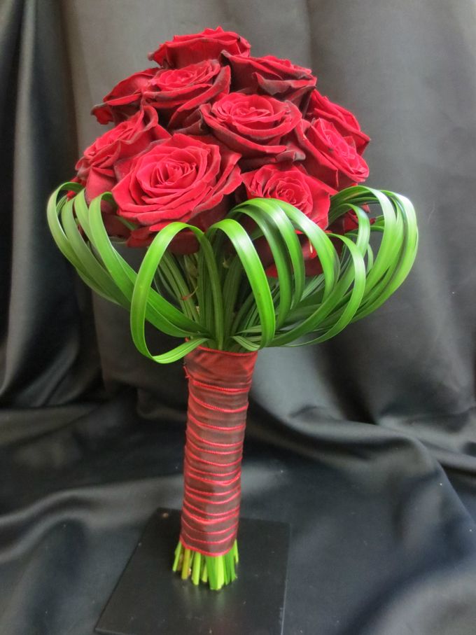 Bruidsboeket met rode rozen en lelieblad afgewerkt lint