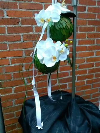 Bruidsboeket  met Orchideeën en linten twee bollen beplakt met skimmiablad. Draagt lekker licht en kan aan de pols gedragen worden.